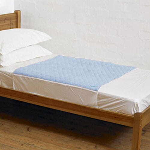 A blue Kylie Bed Pad on a bed