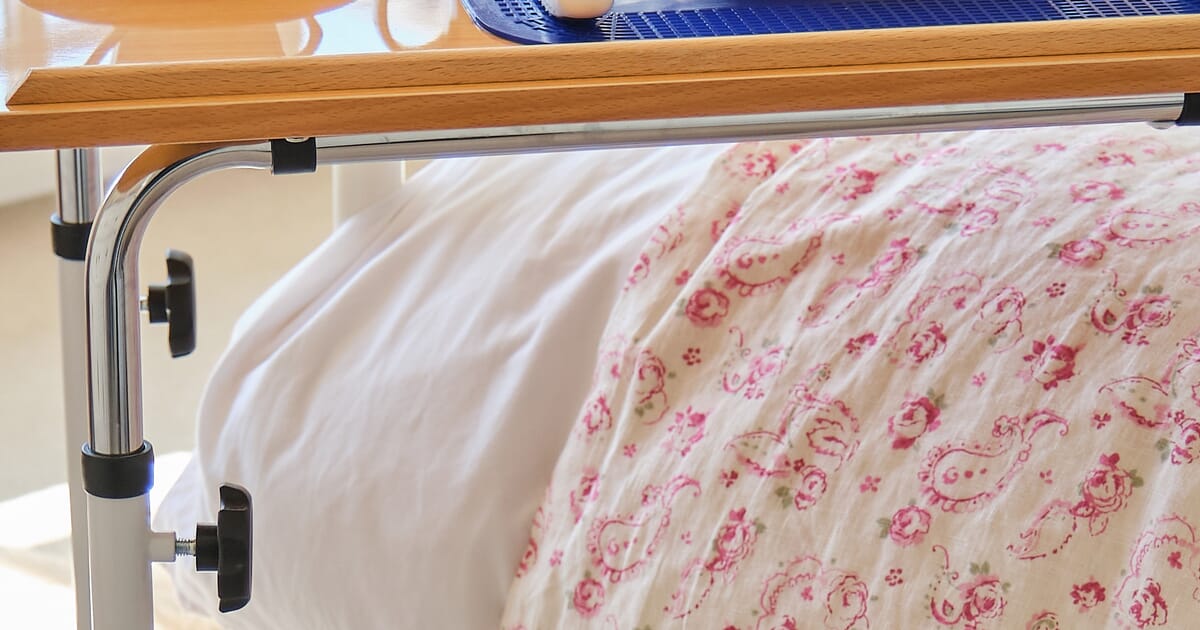 Bedside table that slides under bed outlet